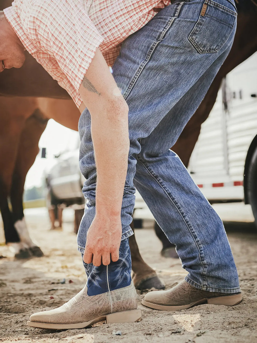 Man putting on a pair of Durango Western Boots.