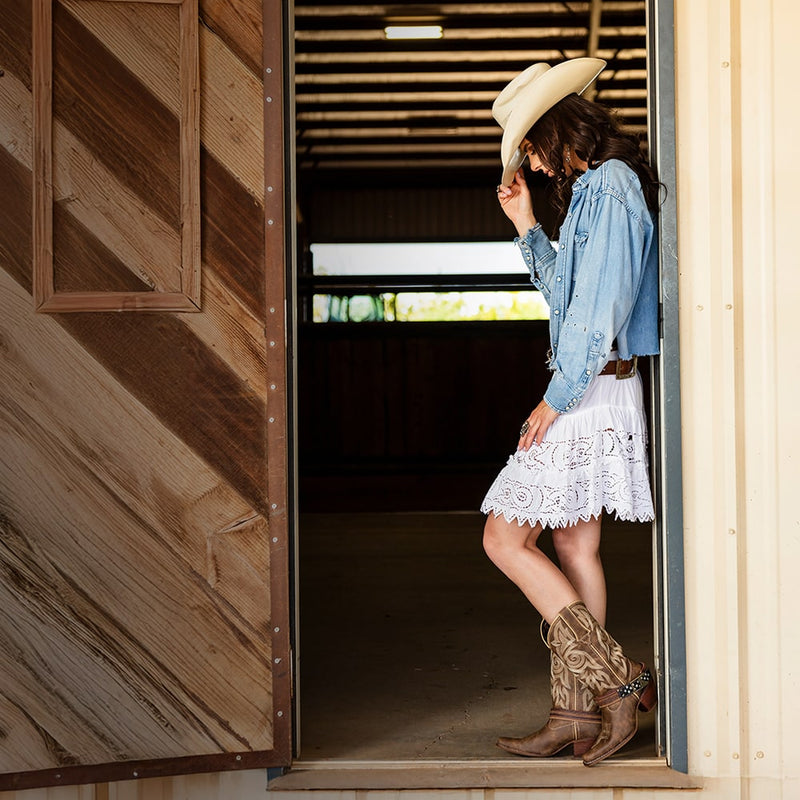 Woman stood in a doorway, wearing a cowboy hat and pair of Women's Durango Crush Flag Accessory Western Boots