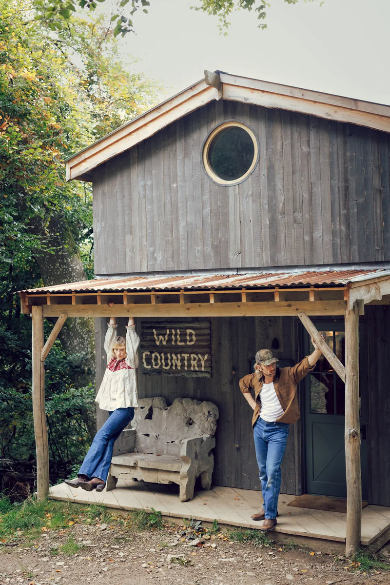 Jenna and Matthew stood under a shelter outside a wooden ranch.