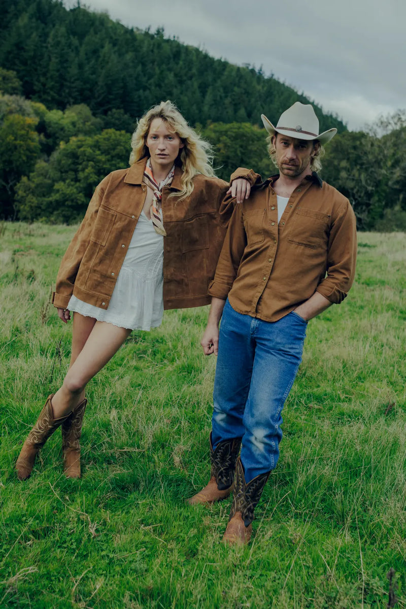Jenna and Matthew standing in a grassy field with trees in the background, both wearing Durango cowboy boots.